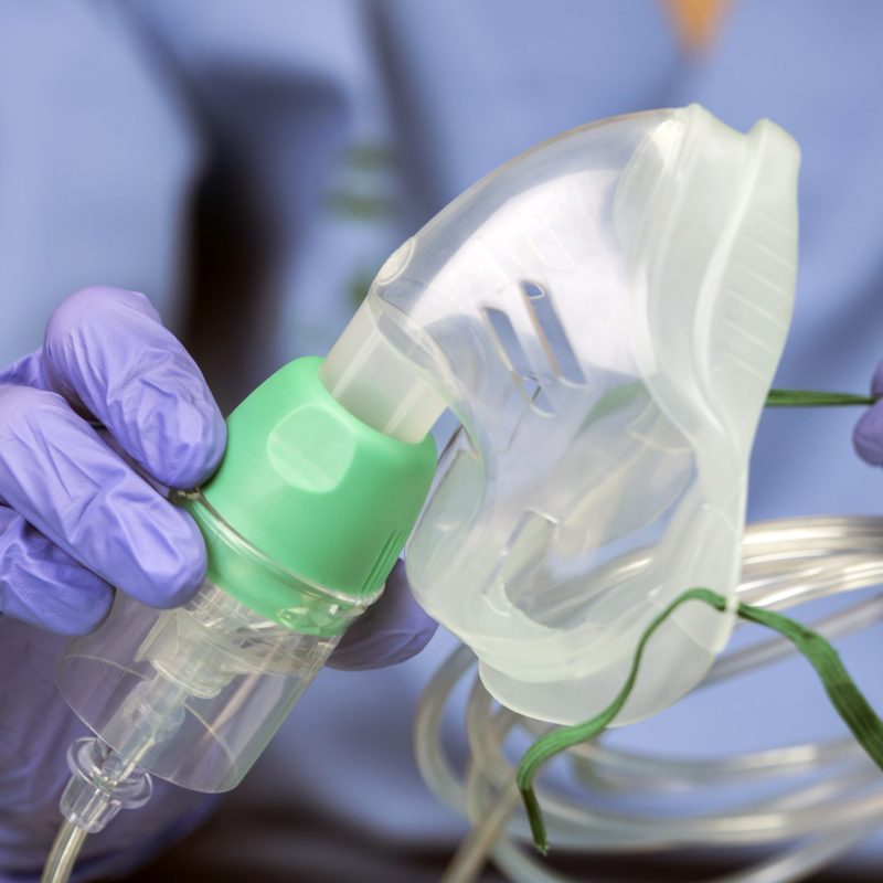 Nurse prepares oxygen mask in a hospital, conceptual image